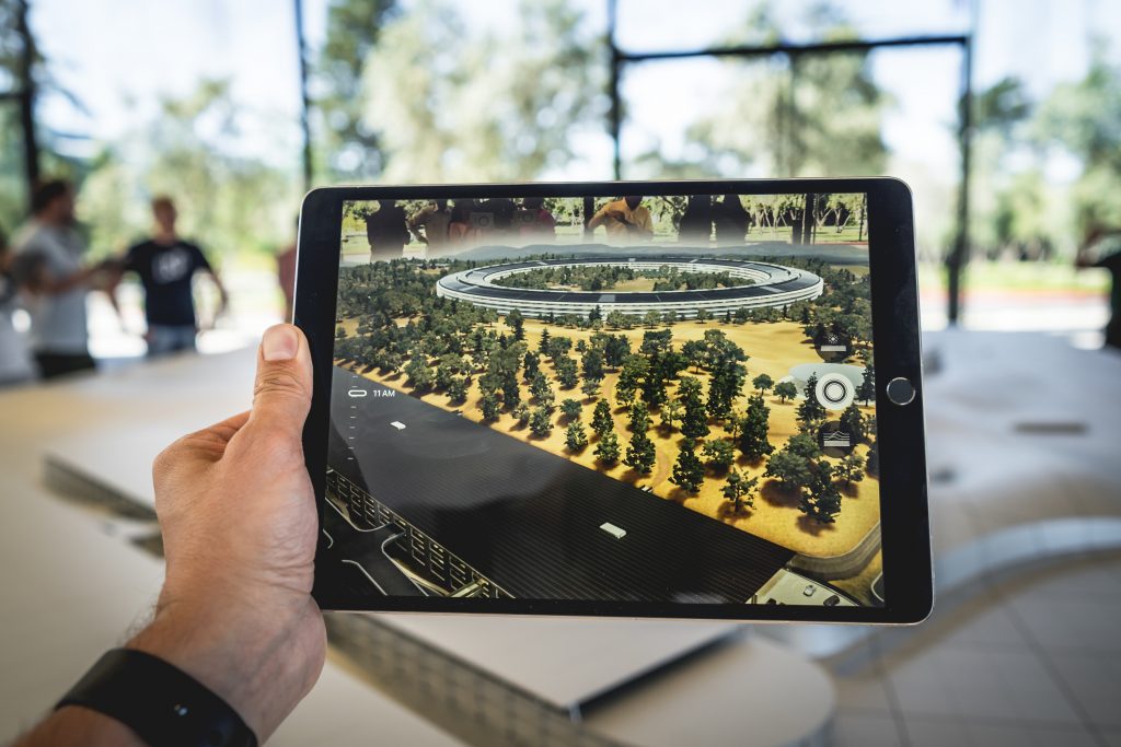Image d'un visiteur utilisant un parcours de visite numérique en réalité augmentée pour s'immerger dans un univers ajouté au réel.